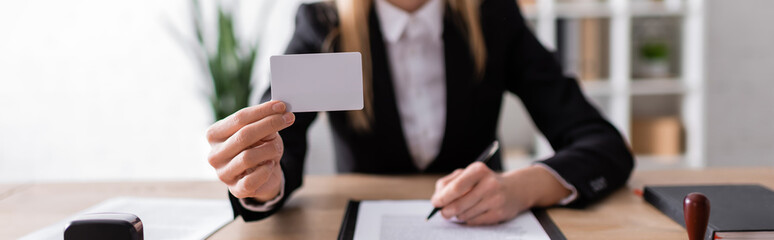 cropped view of notary holding blank business card, banner.