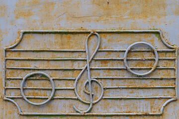 Metal fence of the old music school with decorative symbols in the form of a treble clef and notes...