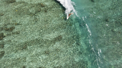 Aerial view of a male surfer riding the huge waves