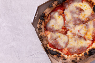  Delicious hot and fragrant pizza diabla with piperoni. Pizza in a box. Pizza delivery. Composition on a gray texture background. Top view. Copy space.Italian food.