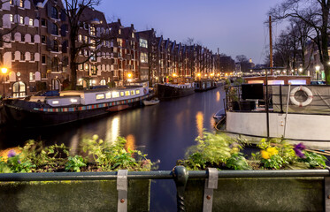 Beautiful old houses on the city waterfront of Amsterdam at sunset.
