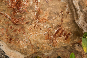 Stone Age hematite or red iron oxide hand prints color the limestone walls of a rock shelter in...