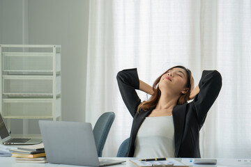 Businesswoman or working lady is stretch themselves or lazily for relaxing on their desk while...