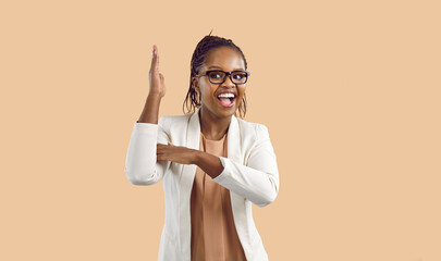 Fototapeta Ecstatic woman raises her hand to attract attention and answer questions isolated on beige background. Smiling smart young african american woman with glasses raises her hand knowing answers. Banner. obraz