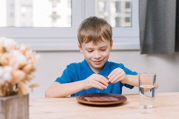 Caucasian little boy took a piece of chocolate to eat.