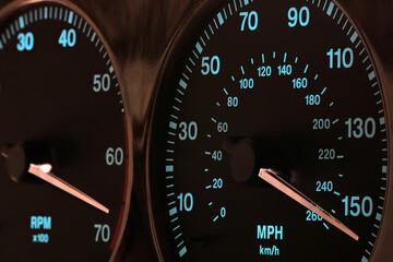 speedometer in car dashboard at full speed in illuminated night mode