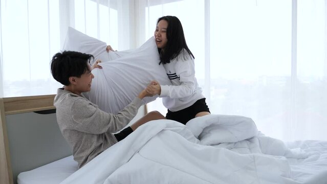 Lesbian couples play with pillows in the bed