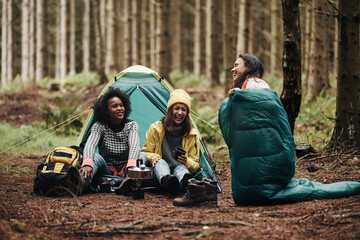 Friends laughing while camping in the woods