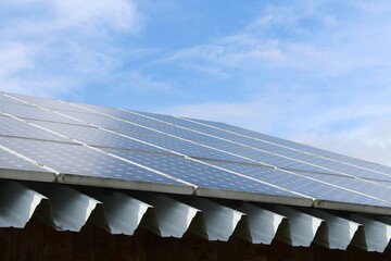 Dach mit Photovoltaik und Regenrinne vor blauem Himmel