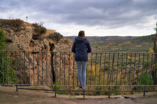 Back view of a person enjoying the view of rural hills in Letur, Spain