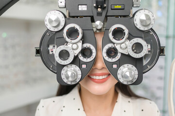 Young female customer being examined visual test using Bifocal Optometry eyesight measurement...