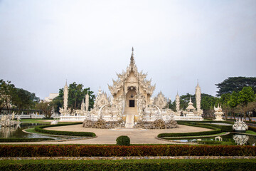 Fototapeta premium Aerial view of Wat Rong Khun, the white temple, at sunrise, in Chiang Rai, Thailand