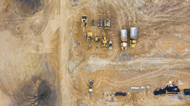 Aerial view of a large construction site with several earthmover machines.