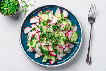 Fresh salad with radishes on a light gray background. Top view, close-up.