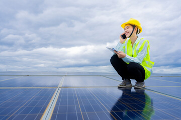A Thai female electrical engineer in Asia is inspecting a solar panel. by recording the condition...