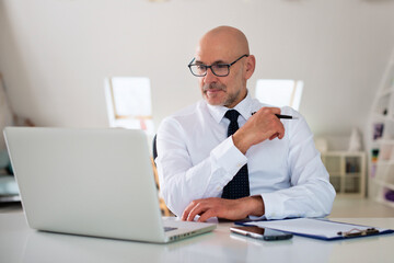 Middle aged businessman woking on laptop at the office