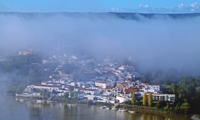 Alcoutim en Portugal entre la niebla matutina. Pueblo situado junto a Sanlúcar de Guadiana en España a orillas del rio Guadiana que sirve de frontera natural entre ambos países.