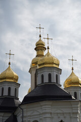 Fototapeta na wymiar Gilded domes of an ancient Orthodox church against the sky. Catherine's Church is a functioning church in Chernihiv, Ukraine. St. Catherine's Church was built in the Cossack Baroque style.