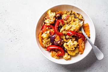 Roasted vegetables salad with bulgur in white bowl. Vegan food concept.