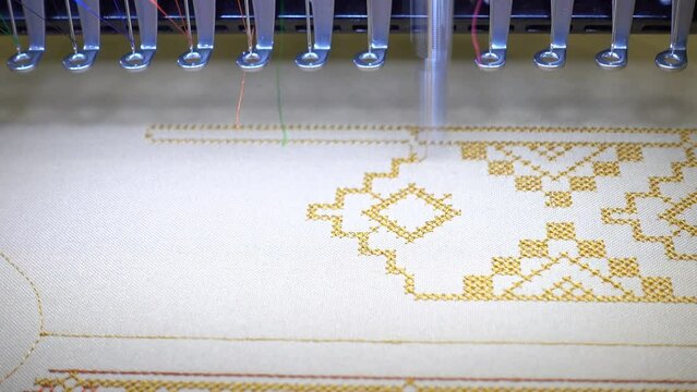4K view of an embroidery machine making a pattern on white fabric