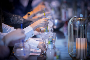 Cocktail series: people celebrating at a table with their glasses, enjoying cocktails in the atmosphere of a cruise party. Ice cubes, citrus peel.