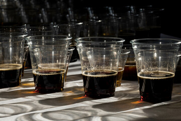 beer in plastic cups in a counter light