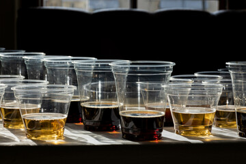beer in plastic cups in a counter light