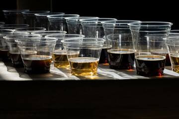 beer in plastic cups in a counter light