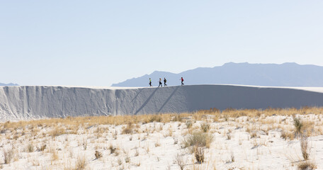 A group of friends hiking the gypsum sand dunes in White Sands National Park 