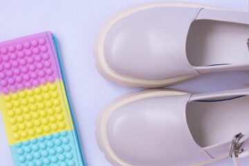 View from above. A pair of women's Mary Jane style shoes with blunt toes. Bright pastel shades....