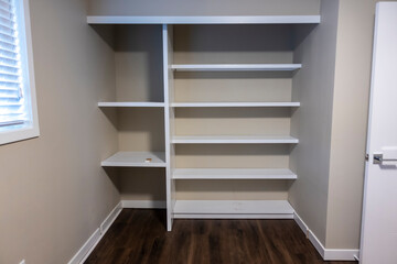 Straight on view of a white shelving system inside a closet in a bedroom