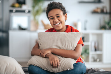 Obraz premium A boy with a pillow in hands looking happy