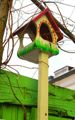 Multicolored birdhouses. Decorative Colored Colorful houses for birds. Bird houses on the fence and wall.