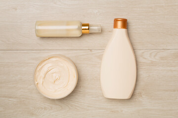 Shower gel and body cream on wooden background, top view