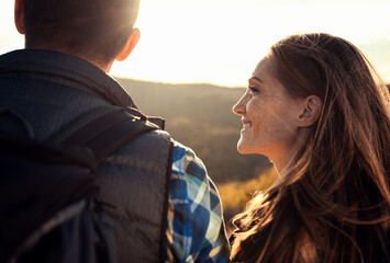 Portrait of couple with backpacks hiking together in nature.