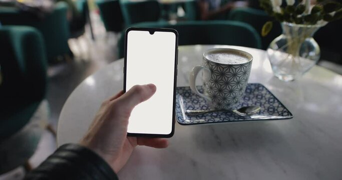 POV, male hand holding smartphone with blank empty screen in cafe, website template
