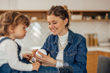 A young mom and a beautiful male toddler having lunch, the child