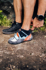 Photo of a man changing his shoes, preparing for climbing.