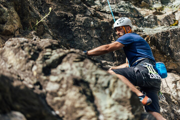Close up of a side view, man looking focused, climbing all the way up.