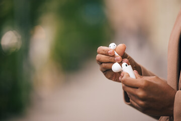 Focus on the female hands, holding earphones.