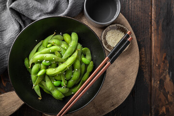 steamed edamame, soybeans on a wooden background, view from above
