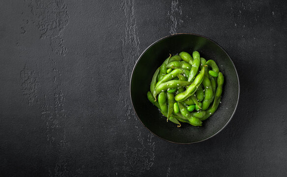 edamame, soybeans on a black background, view from above, copy space