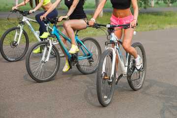 Fototapeta premium cropped image of group of women sitting on bikes.