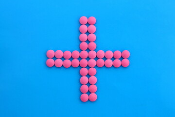 The sign of the medical cross is laid out from pink pills.