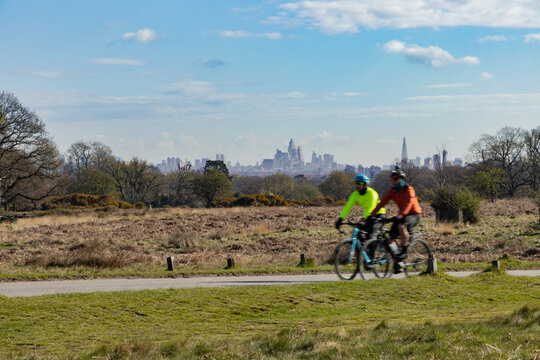 Cyclists in Richmond Park pass a stunning backdrop of the buildings in the centre of London