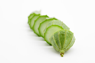 Angled luffa or Ridge gourd slice over on white background, selective focus