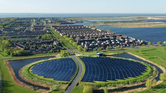 Modern sustainable residential neighbourhood in the city of Almere, The Netherlands, with solar panels farm powering city heating. Aerial view.