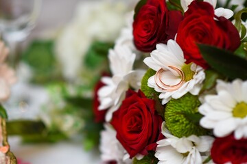 The bride's wedding bouquet of roses. Selective focus. Wedding rings on the bouquet. Wedding.