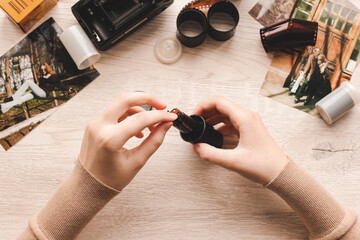 Old photo holding by a teenage girl, retro background with vintage camera, photos and film negative.