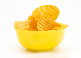 Bowl of tasty ridged potato chips on white background